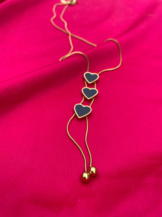 Necklace with heart-shaped pendants on a pink fabric background