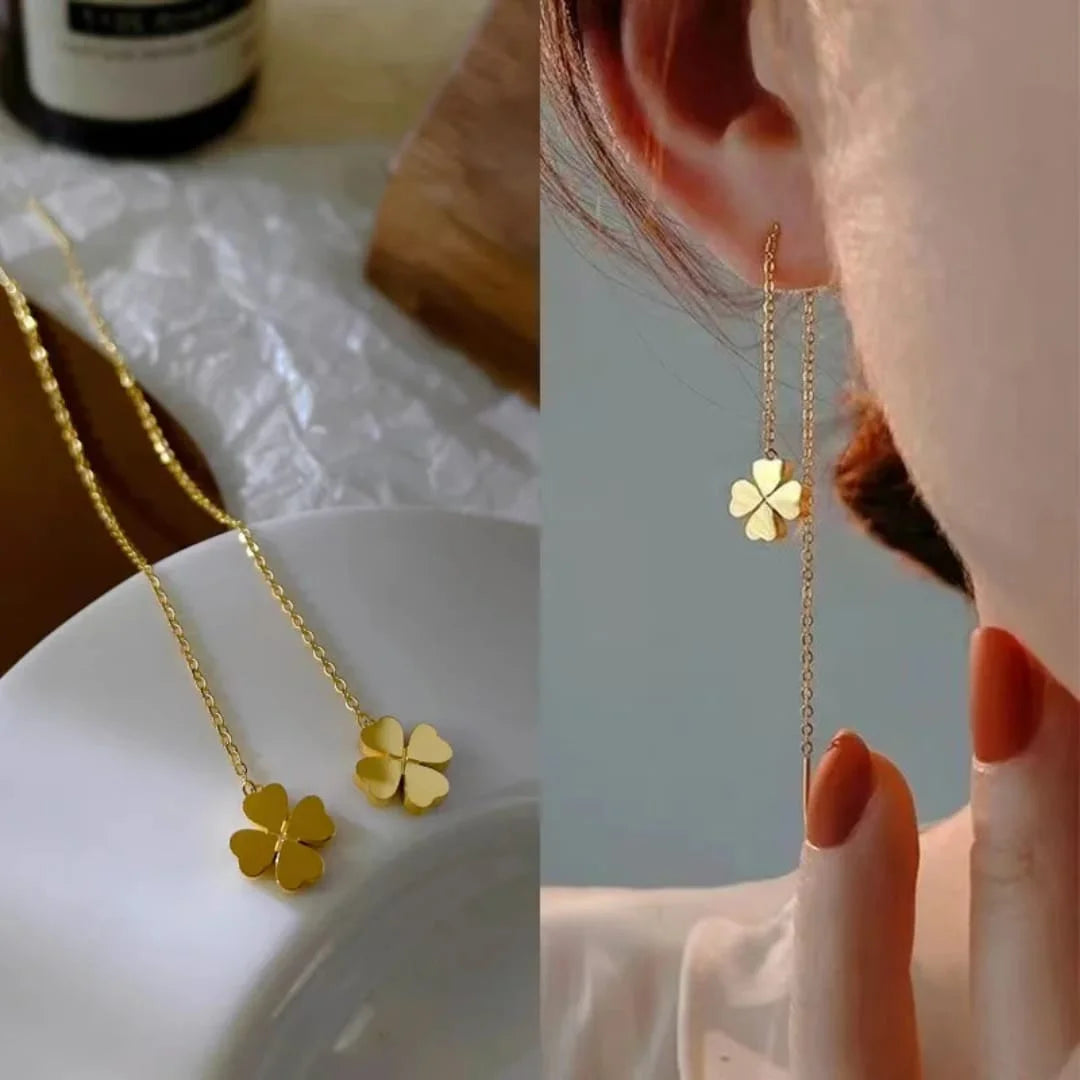 Gold clover threader earrings styled on knit fabric