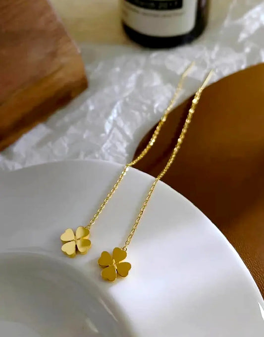Gold clover threader earrings close-up on model