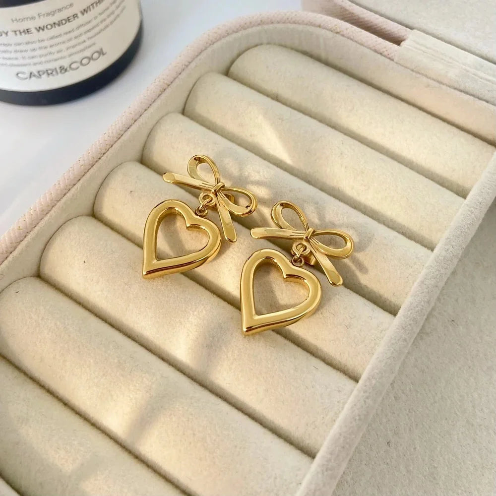 Gold bow heart drop earrings in cream jewelry box