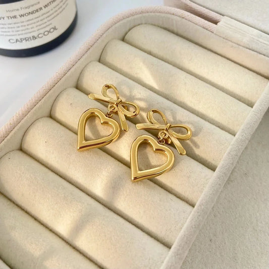 Gold bow heart drop earrings in cream jewelry box