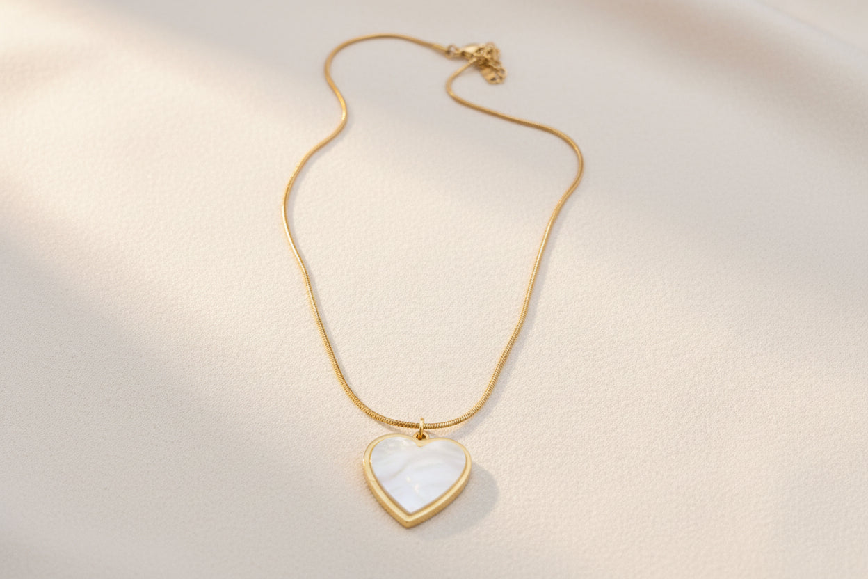 Heart-shaped pendant necklace on a pink fabric background