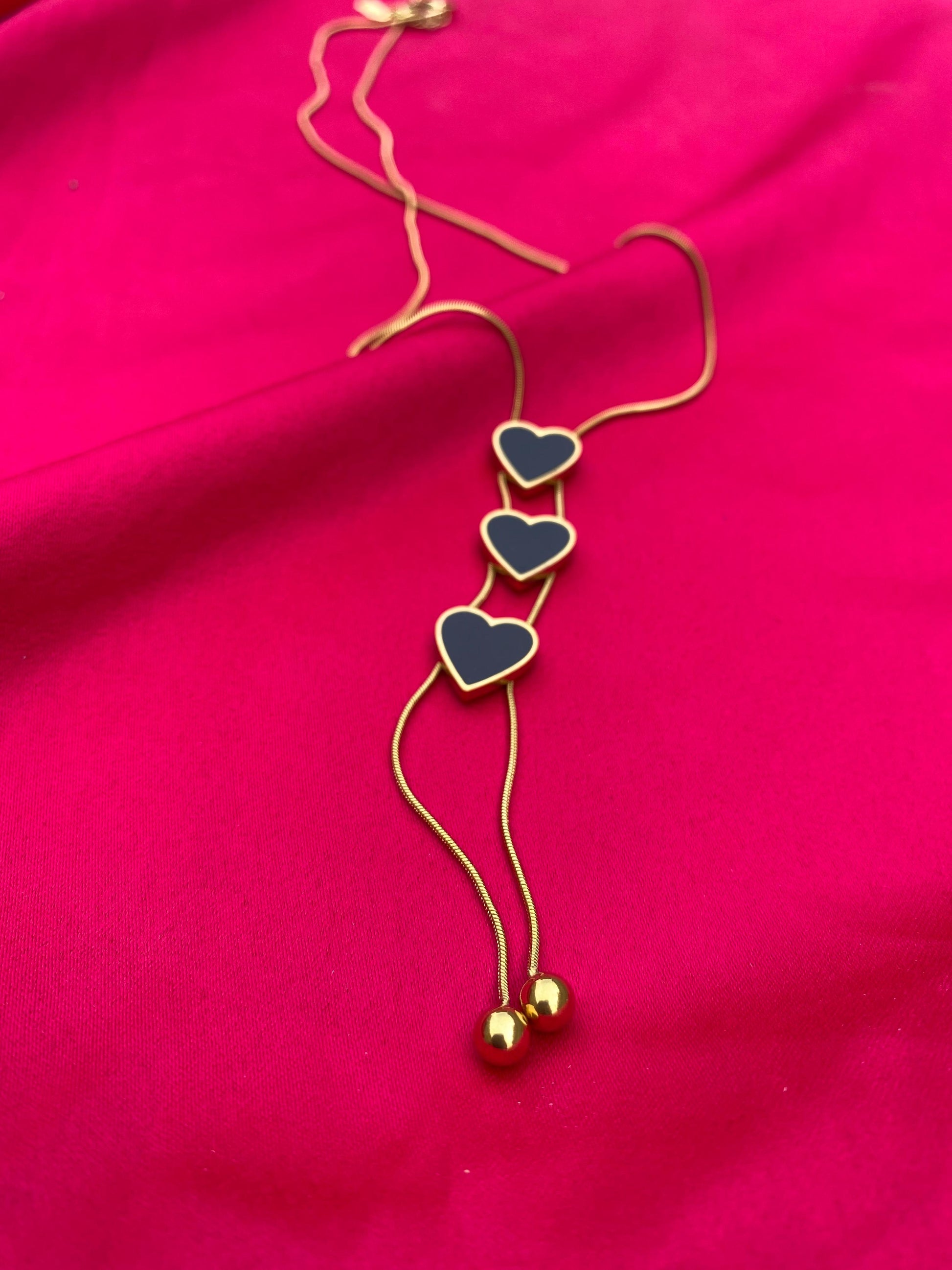 Necklace with heart-shaped pendants on a pink fabric background