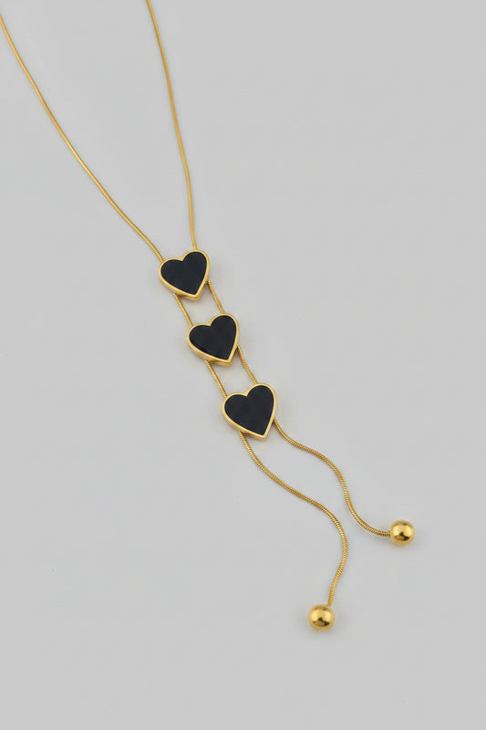 Necklace with heart-shaped pendants on a pink background