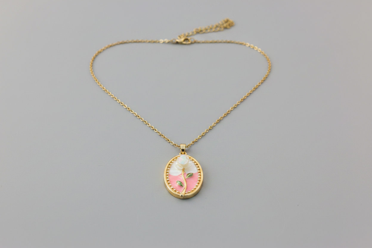 Gold necklace with a pendant on a pink fabric background