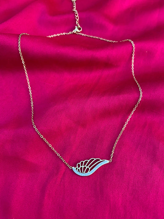 Necklace with a leaf-shaped pendant on a pink fabric background