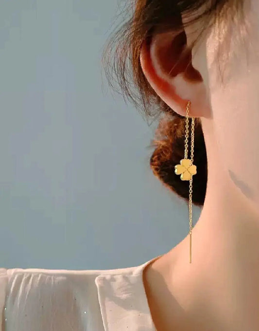 Gold clover threader drop earrings worn on model ear